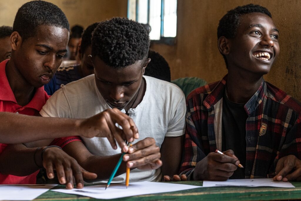 Three young men studying together during a life skills training session