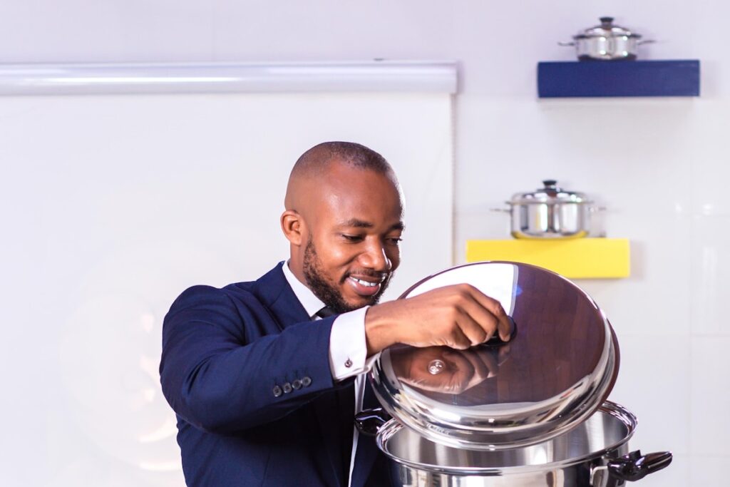 A hospitality graduate in formal service uniform presenting a buffet dish